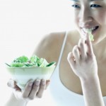 Young woman eating salad